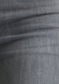 Mörkgrå denimtyg med en något strukturerad yta, som har subtila vertikala linjer och en slät finish.