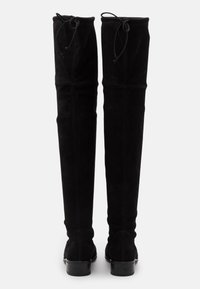 Bottes noires au-dessus du genou en daim doux avec une texture lisse, dotées d'un bout rond et d'un talon carré solide. Détail de laçage en haut.