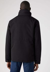 Czarna izolowana kurtka z wysokim kołnierzem i długimi rękawami. Posiada prosty krój i widoczne szwy. Wykonana z trwałego materiału.