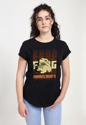 Czarna bawełniana koszulka z żółtą i brązową pikselowaną grafiką z gry Minecraft z przodu, z podwiniętymi krótkimi rękawami i luźnym krojem.