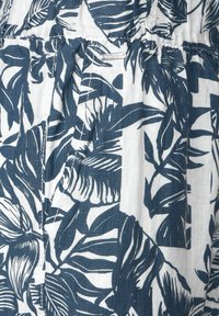 Modrá a bílá tkanina se vzorem s tropickými listy; lehká textura, nařasený pas a jemné detaily šití.