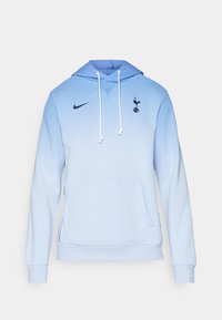 Felpa leggera azzurra con un design a gradiente, tasca frontale, lacci, logo Nike e emblema del Tottenham Hotspur sul petto.