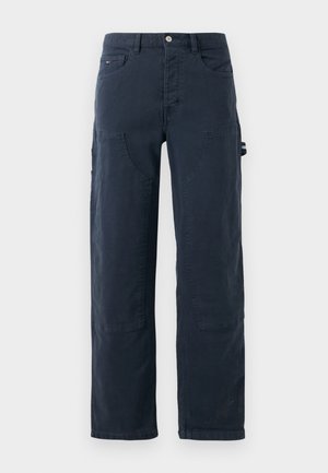 Donker marineblauwe werkbroek met voor- en zijzakken, rechte pijpen en een knoop- en ritsluiting.