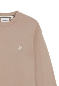 Beige sweatshirt med rund hals og lange ærmer. Har et lille, broderet logo på venstre bryst. Blødt, struktureret stof.