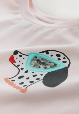 Roosa puuvillane T-särk, millel on prinditud musta-valgekirju koera kujutis türkiissiniste prillide ja punaste huultega, tekstuurse tausta ees.