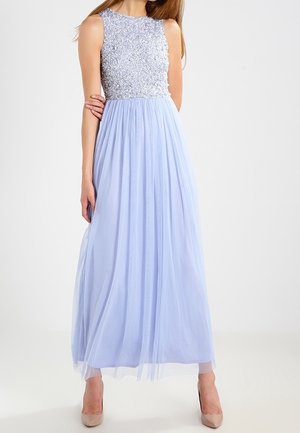 Ärmelloses hellblaues Abendkleid mit besticktem Oberteil und fließendem Chiffonrock, kombiniert mit hautfarbenen High Heels.