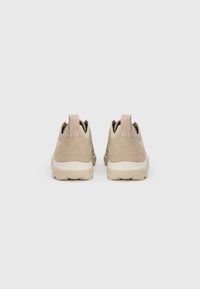 Μπεζ αθλητικά παπούτσια με υφή σουέτ και επάνω μέρος από δίχτυ, με έλξη στο πίσω μέρος και ελαφριά λαστιχένια σόλα ανοιχτού χρώματος.