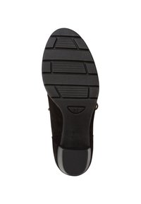 Suela de zapato negra con agarre de goma texturizada, con un ligero tacón. Tamaño marcado como 37. Acabado suave con patrones de canales y estrías.
