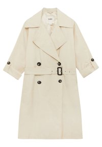 Trench-coat crème à double boutonnage avec boutons noirs, larges revers, manches retroussées avec pattes de boutonnage, et taille ceinturée.