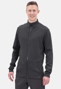 Graue Zip-Jacke aus weichem Material. Hat einen hohen Kragen, Seitentaschen und einen Markenstreifen entlang des Reißverschlusses. Regelmäßige Passform.