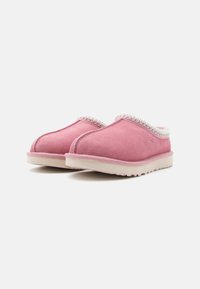 Chaussures slip-on en daim rose avec un accent texturé blanc le long de l'encolure et une semelle en caoutchouc légère, présentant un design à bout arrondi.