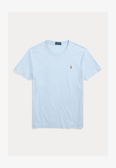 Šviesiai mėlynas medvilninis marškinėlis su apvalia iškirpte ir trumpomis rankovėmis. Kairėje krūtinės pusėje yra mažas siuvinėtas logotipas. Lygios tekstūros.