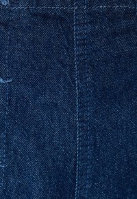 Tummansininen denim-kangas, jossa on sileä pinnan rakenne. Saumurivarat ovat selvästi näkyvissä ja pinnassa on hieno kiilto. Kokonaisväri on syvän sininen.