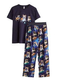Pyjamasæt med en sort kortærmet skjorte, der har farverige hundetryk, og marineblå bukser med forskellige hundemønstre på en galaksebaggrund.
