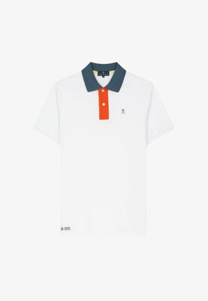 Polo blanco de manga corta con cuello azul verdoso oscuro, tapeta de botones naranja, pequeño logo de palas cruzadas en el pecho y texto cerca del dobladillo inferior.