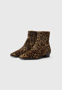 Bottes chevilles en imprimé léopard en matériau doux, avec un bout pointu, une fermeture éclair et un petit talon carré. Le design présente une surface texturée.