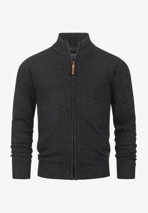 Felpa zip grigia scura con colletto e polsini a costine, caratterizzata da un piccolo tag in pelle vicino alla cerniera e una texture a maglia liscia.