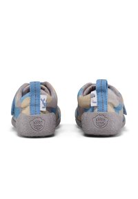 Los zapatos para niños en azul y beige cuentan con una parte superior de tela suave con un patrón de camuflaje, una correa de velcro y una suela de goma gris texturizada con marca.