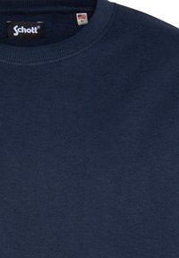 Marineblauw langemouwen shirt met ribbelende ronde halslijn, gemaakt van zachte stof. Bevat een label met de merknaam en maat.