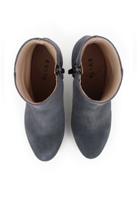 Stivali ankle in suede grigio con punta affilata e interno liscio. Presentano un accento con fibbia nera sul lato. Marchio visibile all'interno.