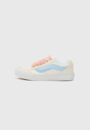 Lavtopet cremefarvet sneakers med lyseblå sidestribe, hvid sål og flerfarvede snørebånd i pink, orange og hvid på en lys baggrund.