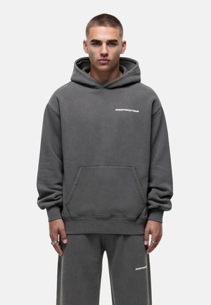 Gray hooded sweatshirt with a front pocket, featuring white logo text on the chest. Fabric appears soft with a relaxed fit.