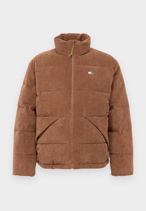 Brun kordfløyels pufferjakke med høy krage, full frontglidelås, to skrå frontlommer, og liten rektangulær logo på venstre bryst.