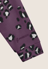 Tessuto elastico viola con macchie di leopardo bianche e nere, dotato di un logo rialzato "FREDDY" sul bordo inferiore.