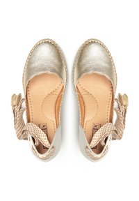 Chaussures espadrilles dorées métalliques avec bords festonnés, semelle intérieure en cuir et brides tressées pour la cheville. Texture lisse et design à bout rond.