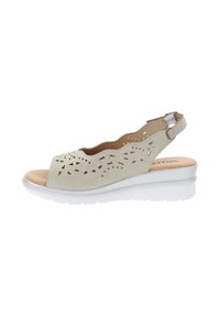 Sandalo slingback beige con design a taglio, materiale scamosciato morbido, punta aperta e suola a cuneo bianca. Presenta elastico per una vestibilità sicura.
