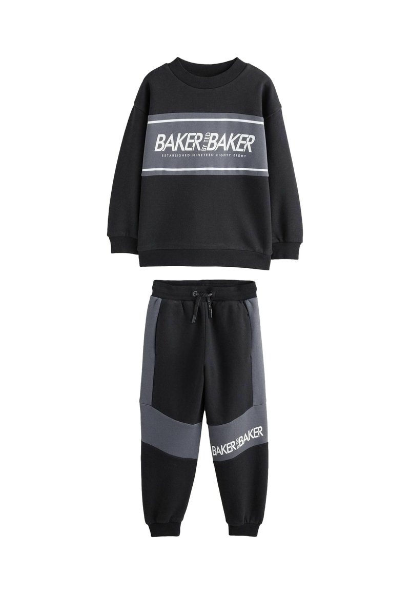 Czarny dres składający się z bluzy i spodni dresowych, z szarym poziomym paskiem oraz napisem "BAKER by BAKER". Wykonany z miękkiej tkaniny o gładkiej fakturze.