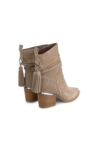 Stivali alla caviglia in suede beige con design arricciato, borchie in tonalità argento e dettagli con frange. Punta quadrata e tacco a cilindro a righe.
