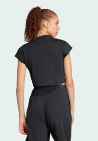 Svart kortärmad träningstopp med mjukt tyg och rund halsringning. Matchas med svarta lösa byxor.