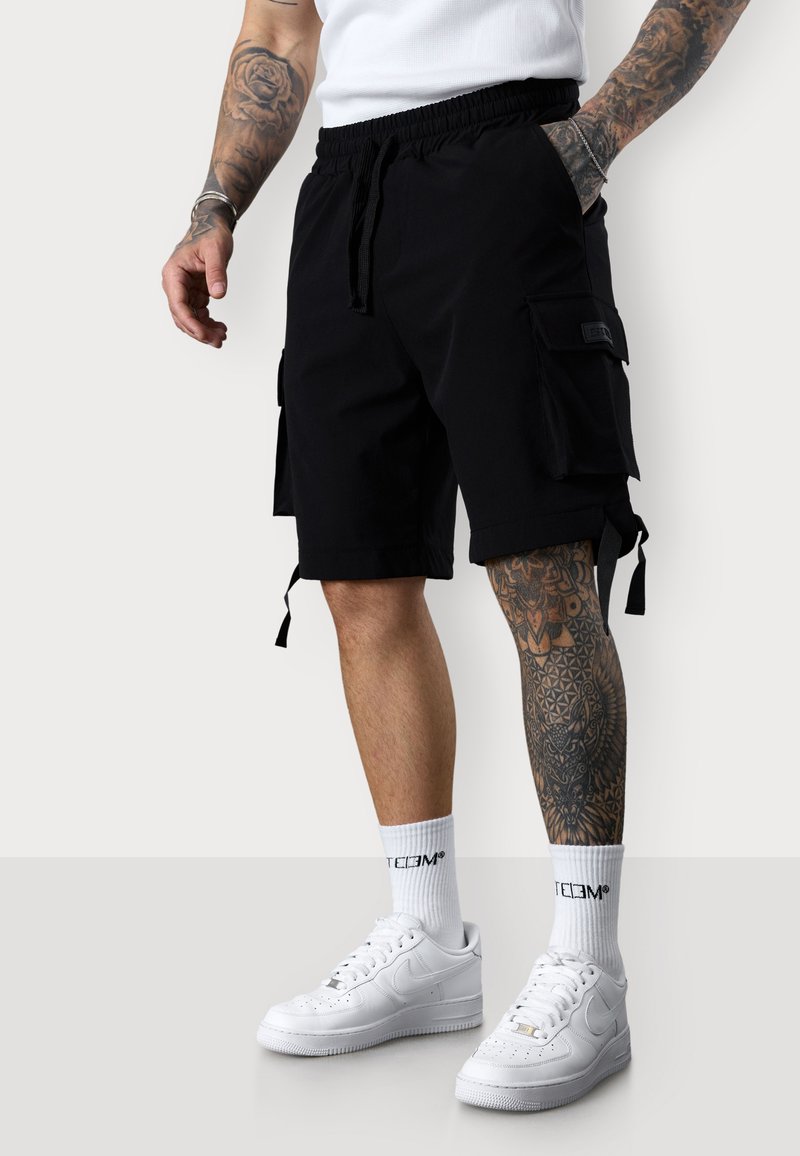 Schwarze Cargo-Shorts mit elastischem Bund, Seitentaschen und Kordelzug. Verfügt über mehrere Seitentaschen und Bindebänder am Saum.