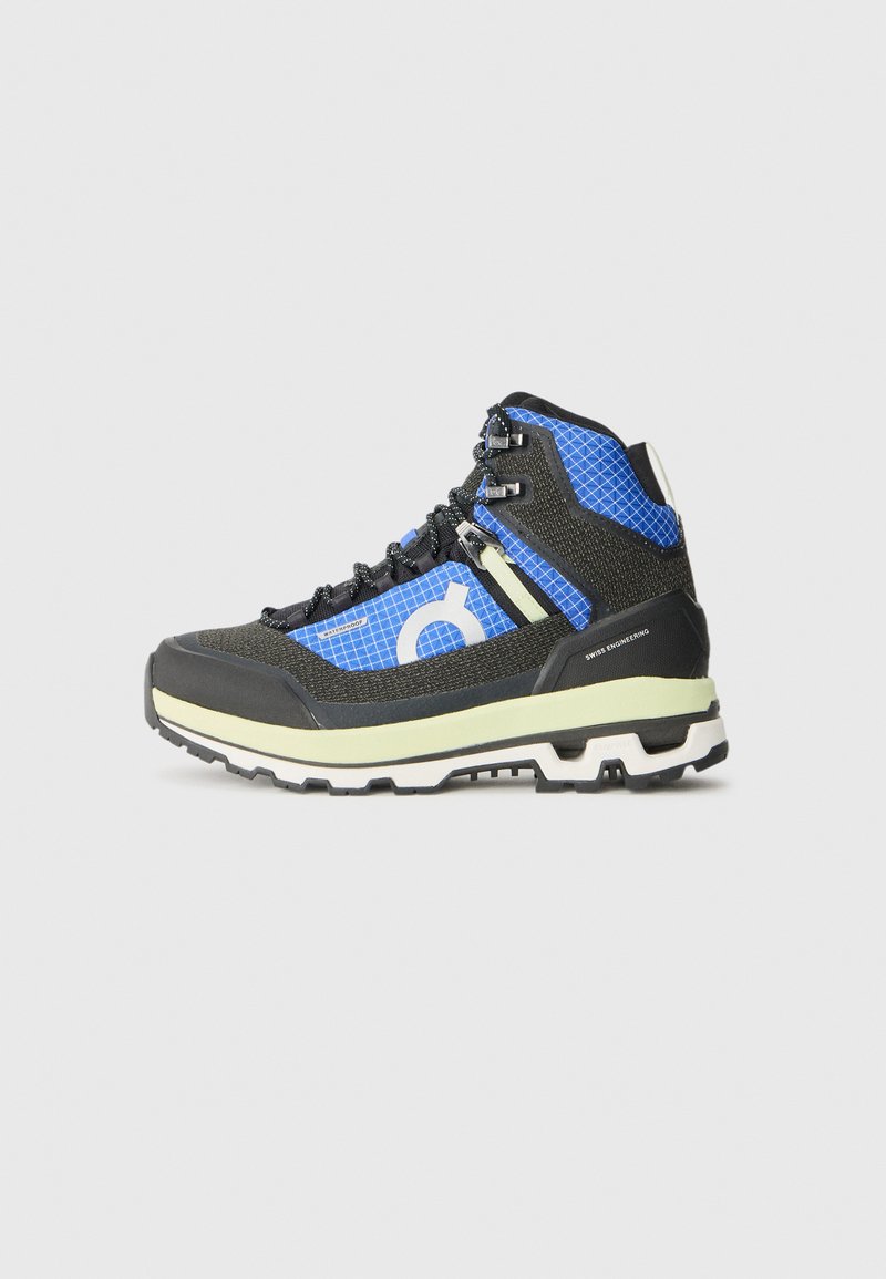 Wysokie buty trekkingowe w czarnym i niebieskim meshu, z gumową podeszwą, wzmocnioną osłoną na palce oraz teksturowanymi akcentami zapewniającymi przyczepność i wsparcie.