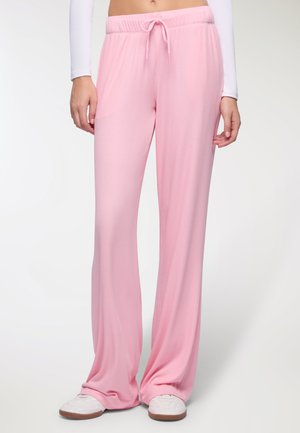 Pantaloni rosa a coste con gamba ampia presentano una vita elastica con coulisse. Il tessuto appare morbido e leggero.