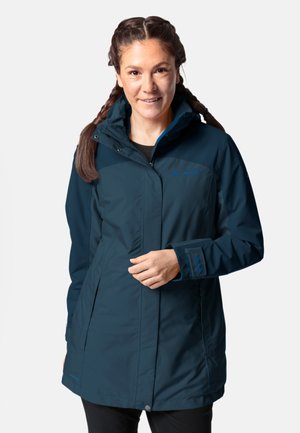 Marineblauer wasserdichter Parka mit Kapuze, ausgestattet mit einem durchgehenden Reißverschluss, Druckknöpfen und Brustlogo. Glatte Textur und knielanger Schnitt.