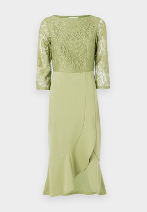 Rochie verde cu un bust din dantelă și mâneci trei sferturi, având fustă netedă, drapată și margine evazată. Detaliu floral pe întreaga suprafață.