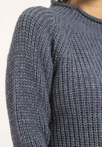 Pull en tricot bleu marine avec un motif texturé, doté d'un col rond côtelé et d'un léger éclat provenant de fils métalliques.
