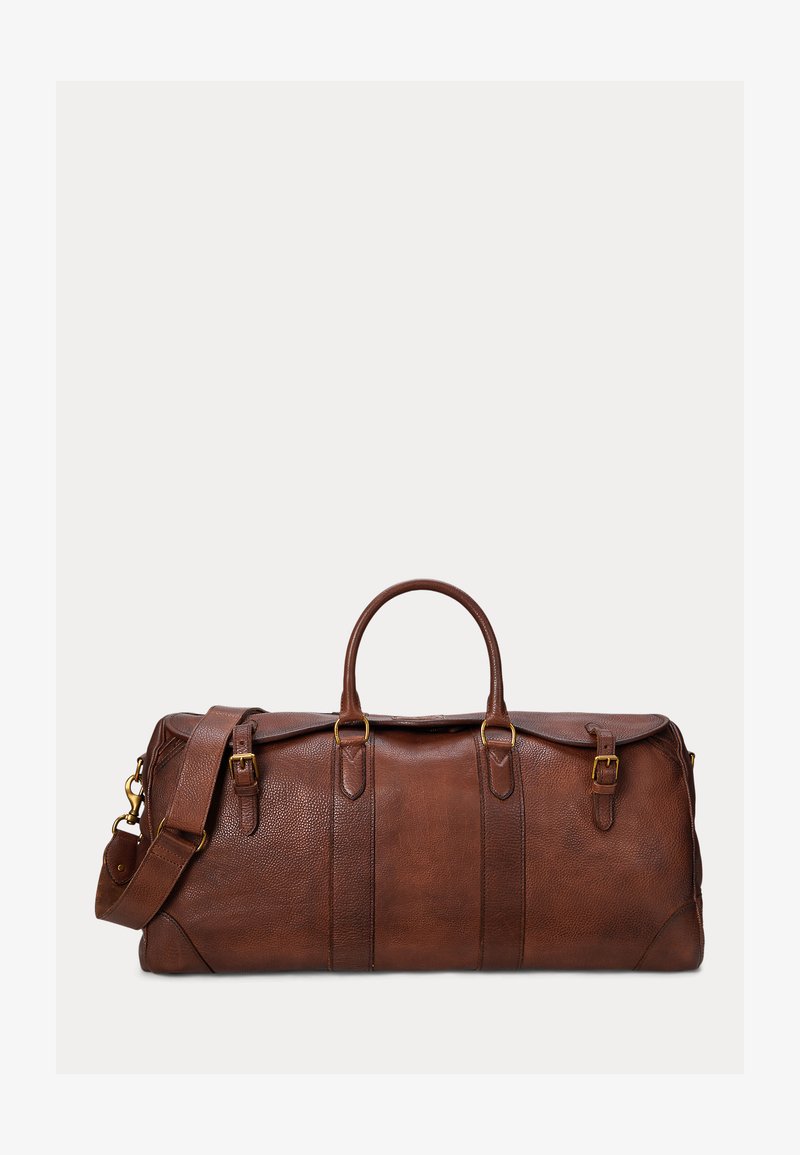 Brązowa skórzana torba podróżna z dwoma górnymi uchwytami, regulowanym paskiem na ramię oraz złotymi klamrami na przodzie i bokach.