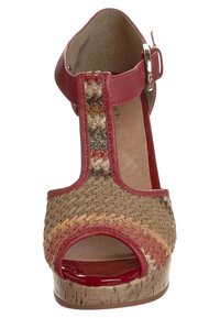 Sandały na koturnie z otwartymi palcami, wykonane z plecionej słomy w naturalnych odcieniach, z czerwonymi skórzanymi akcentami i paskiem z klamrą zapewniającym pewne dopasowanie.