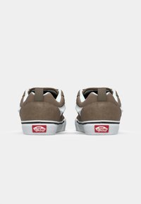 Braune Wildleder-Sneaker im Niedrigschnitt mit weißen Akzenten, schwarzem Besatz und einem roten Logo-Patch an der Ferse. Verfügt über eine Stoffschlaufe auf der Rückseite für ein einfaches Anziehen.