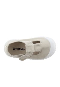 Scarpa in tela beige con suola in gomma bianca, dotata di dettagli ritagliati e una fibbia. Design piatto adatto per l'abbigliamento casual. Logo del marchio visibile all'interno.