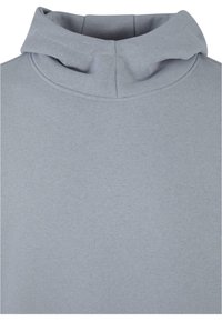 Sudadera de color gris claro con cuello alto, textura suave y detalles de costura mínimos. La tela parece suave y tiene un diseño casual.