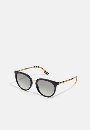 Óculos de sol estilo gato preto com lentes cinza em gradiente, detalhes em metal dourado e hastes listradas multicoloridas em preto, laranja e bege.