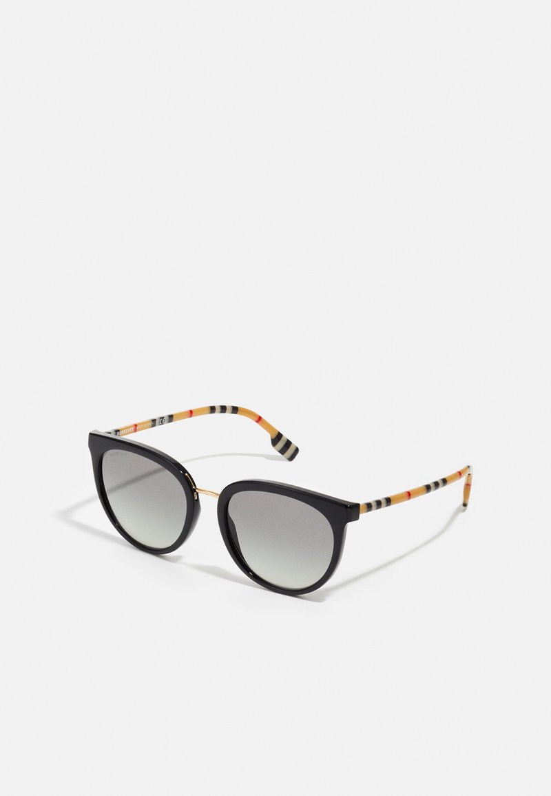 Óculos de sol estilo gato preto com lentes cinza em gradiente, detalhes em metal dourado e hastes listradas multicoloridas em preto, laranja e bege.