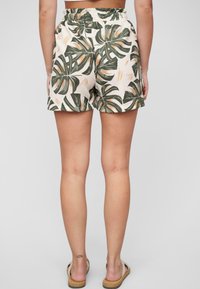 Lightweight, cream shorts featuring a green and orange tropical leaf pattern, elastic waistband, and relaxed fit.