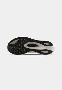 Black and white athletic shoe sole with a textured pattern, featuring large cutouts and small circular perforations for traction.