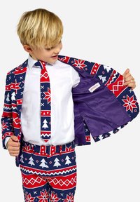 Marinblå kostym med röd och vit geometrisk mönstring; inkluderar en matchande slips. Inuti finns lila foder och en etikett.