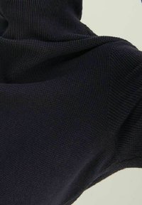 Marineblauwe trui met ribbeltextuur, met een hoge kraag en zachte stof. Het ontwerp is getailleerd met lange mouwen en een gematigde rek.